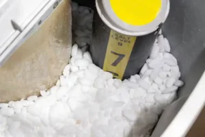Close-up of a water softener tank filled with white salt pellets, featuring a cylindrical marker with a yellow top labeled "Salt Level 7." Ensure optimal performance and consider scheduling regular water softener repair to maintain efficiency.